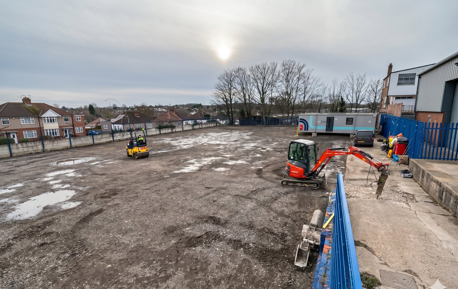 Oncue depot before — muddy yard with roller and excavator