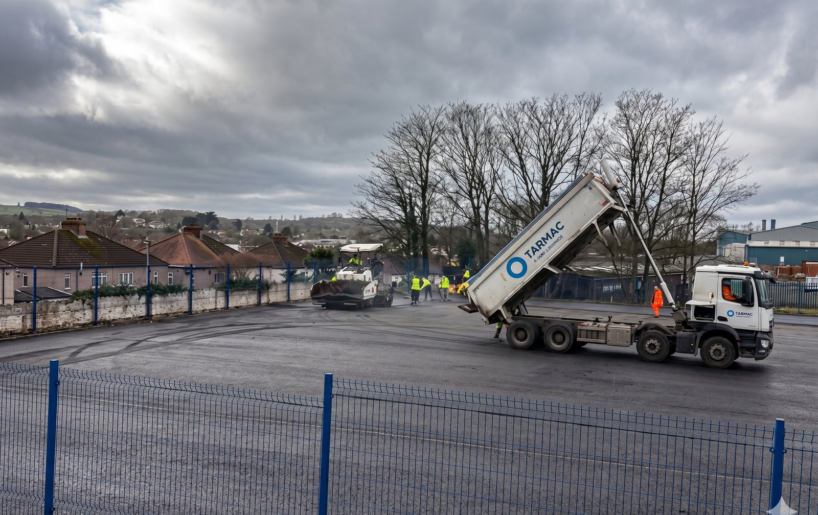 Tarmac being laid — tipper lorry and paver on site