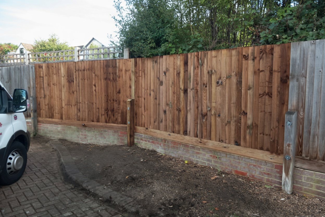 New pressure-treated closeboard fence on brick plinth with concrete posts