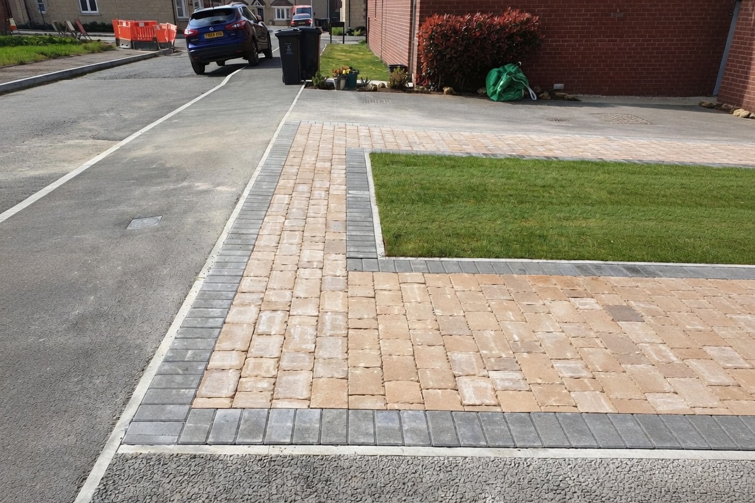 Block-paved driveway with a parked car and finished kerb edging