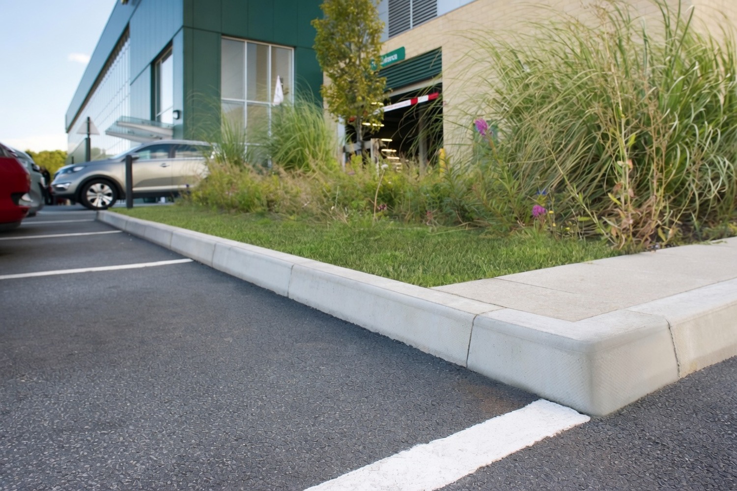 Concrete kerbing edging a car-park bay against grass