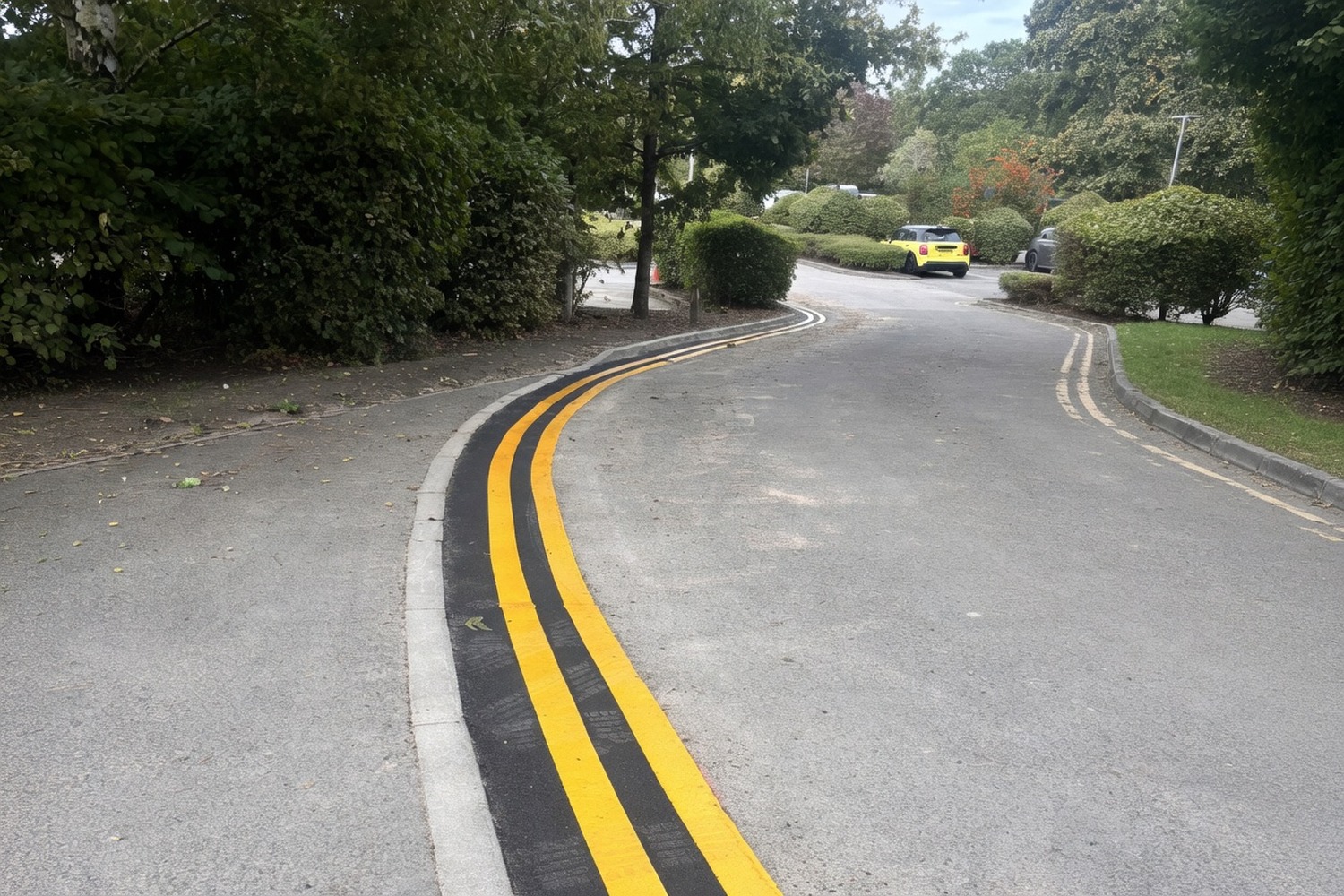Curved road reinstated with hot-mix tarmac and new thermoplastic double yellow lines